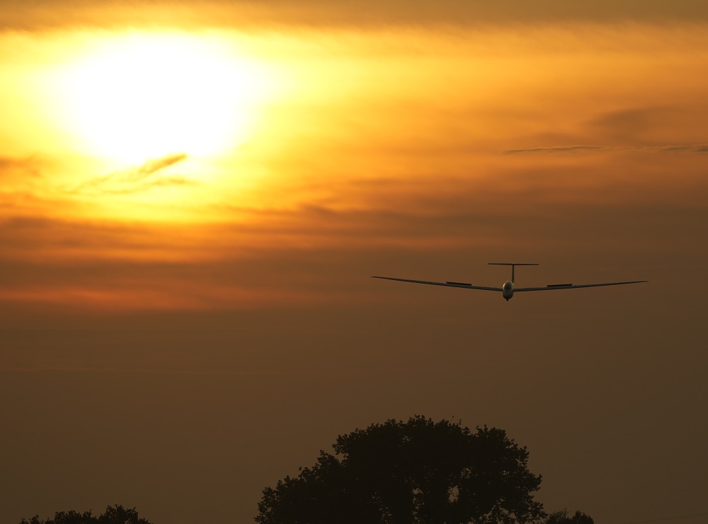 Segelflugzeug landet bei Sonnenaufgang